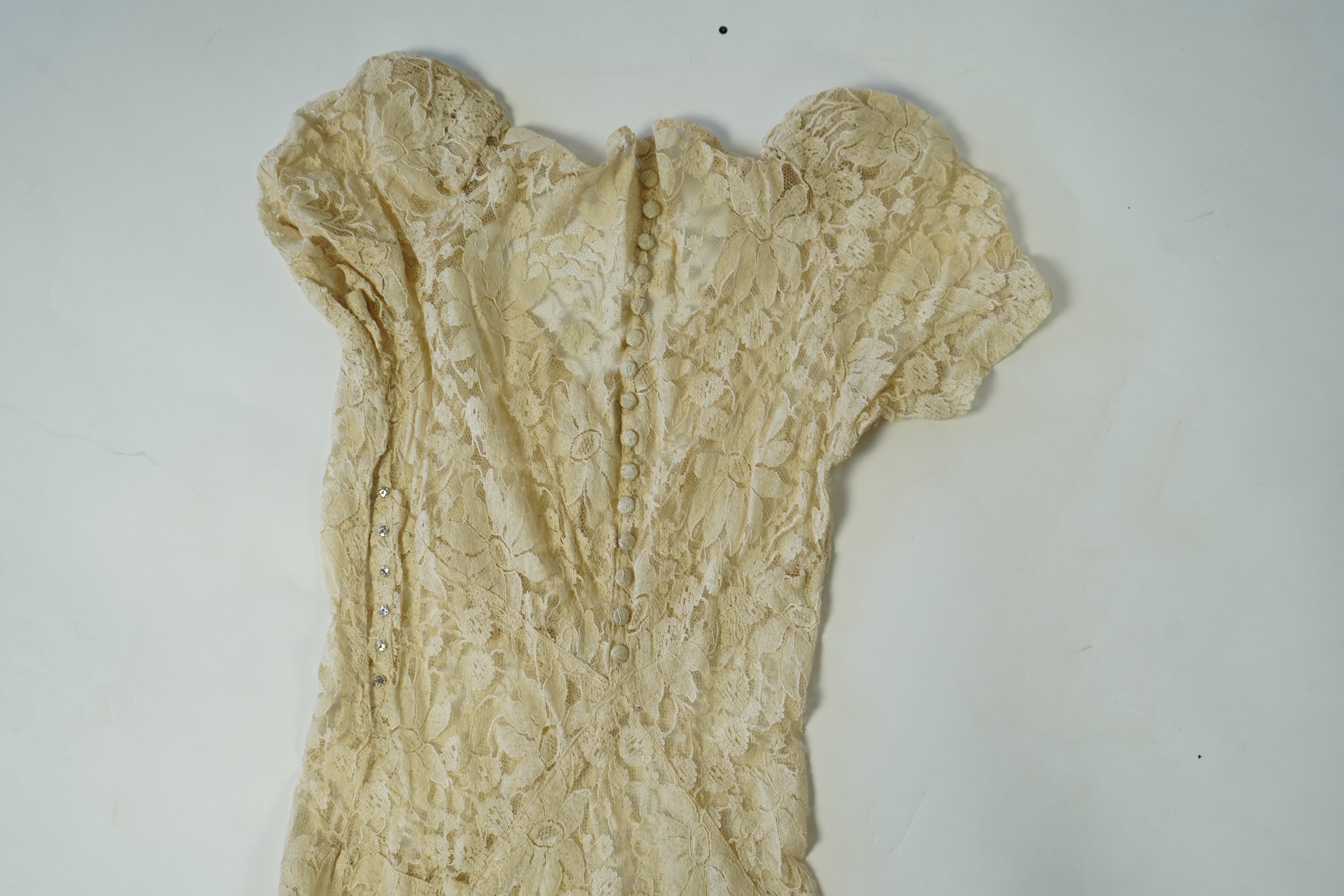 An early 1940's cream cotton lace and taffeta evening dress, with matching taffeta petticoat, possibly worn as a wedding dress., Dress 144cm long. Condition - minor repairs needed to lace in places and laundering to remo